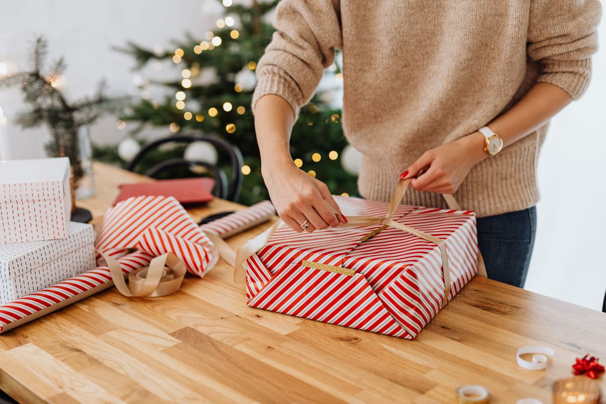 Christmas gifts for her wrapped in festive paper with ribbon